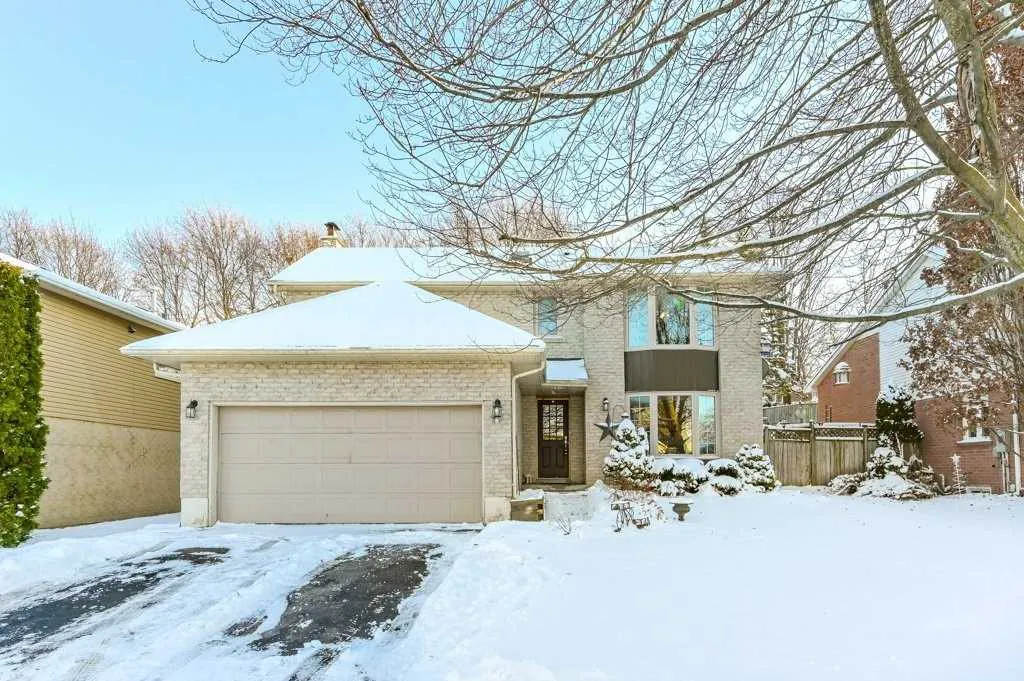 Two storey grey brick home with attached 2-car garage located in the Outer Downtown Orangeville neighbourhood