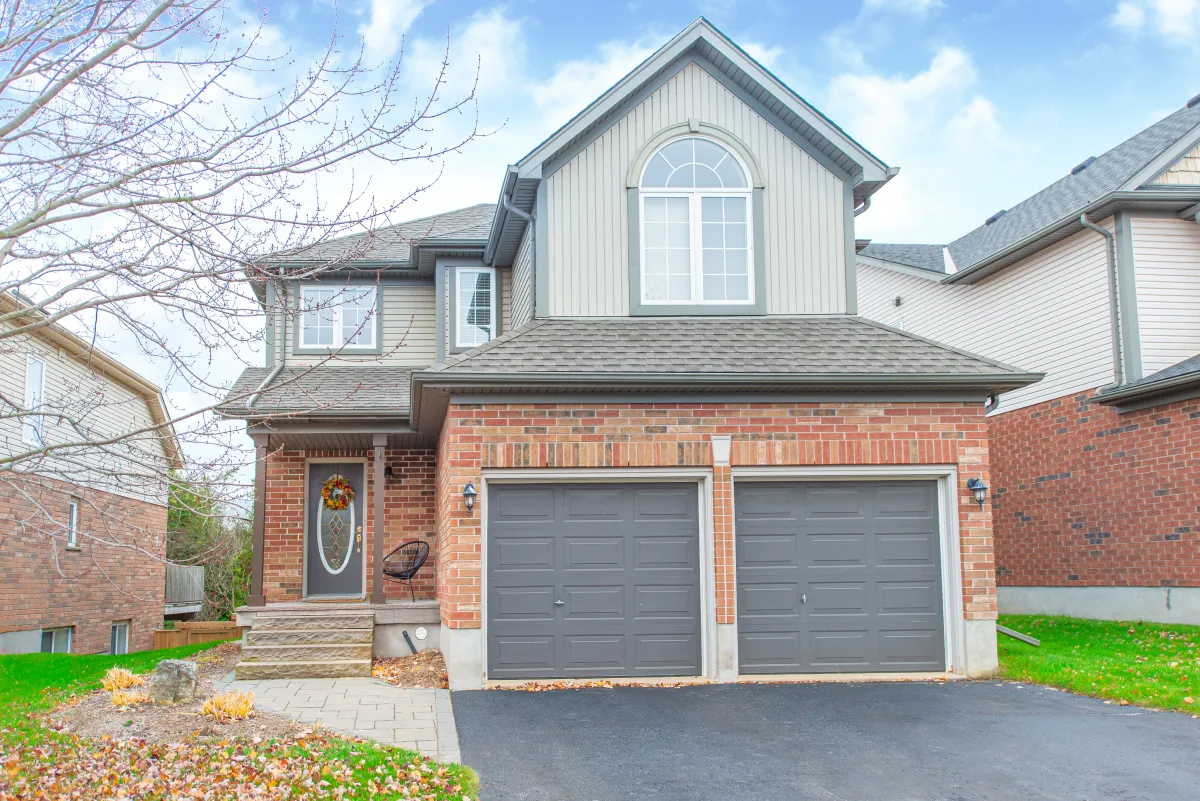 2-storey red brick and grey siding detached home with attached 2-car garage in the Settler's Creek neighbourhood of Orangeville