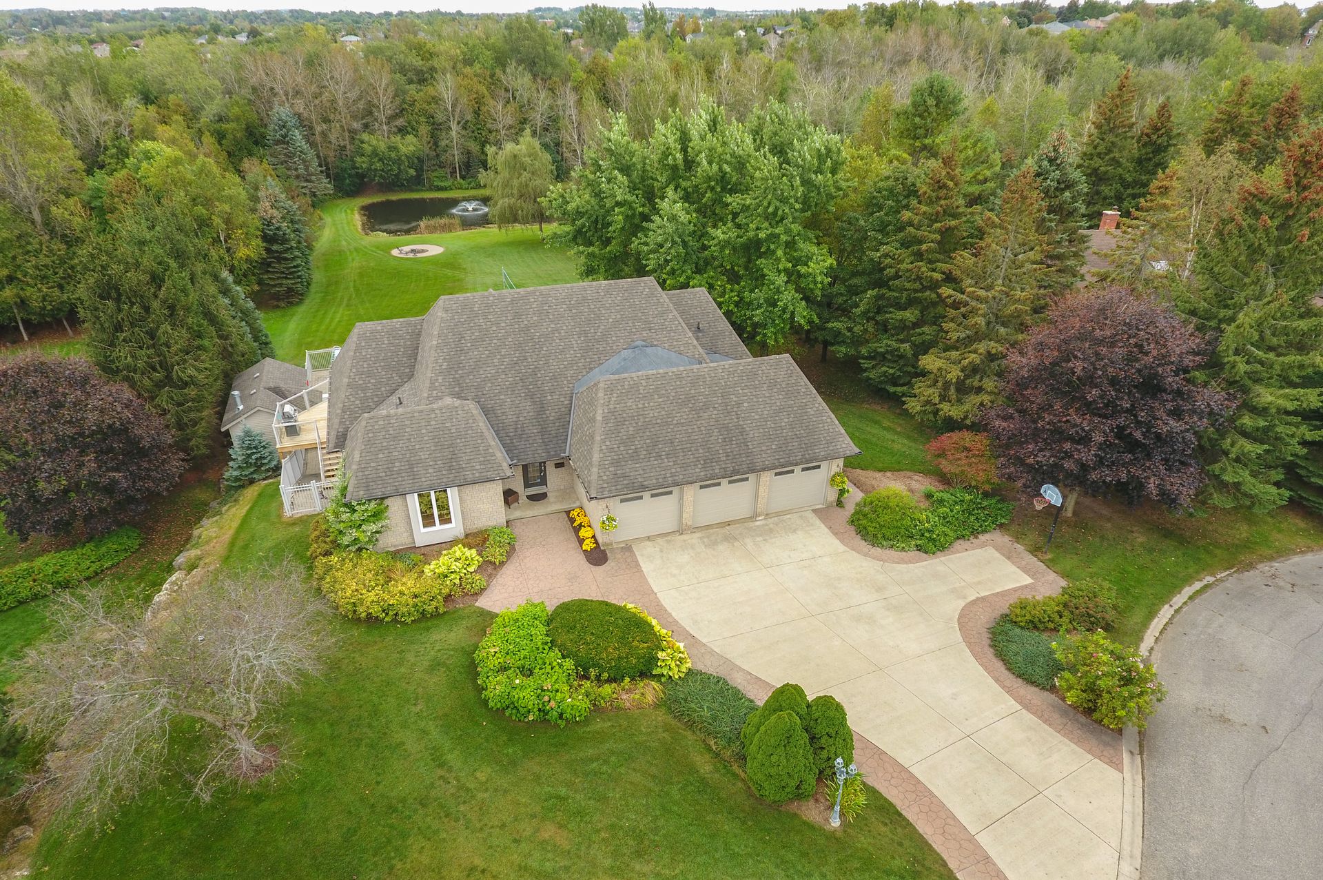 Large detached multi-level home with attached 3-car garage on spacious property, with gardens and pond in the back yard, surrounded by mature trees located in Starrview Acres in Mono