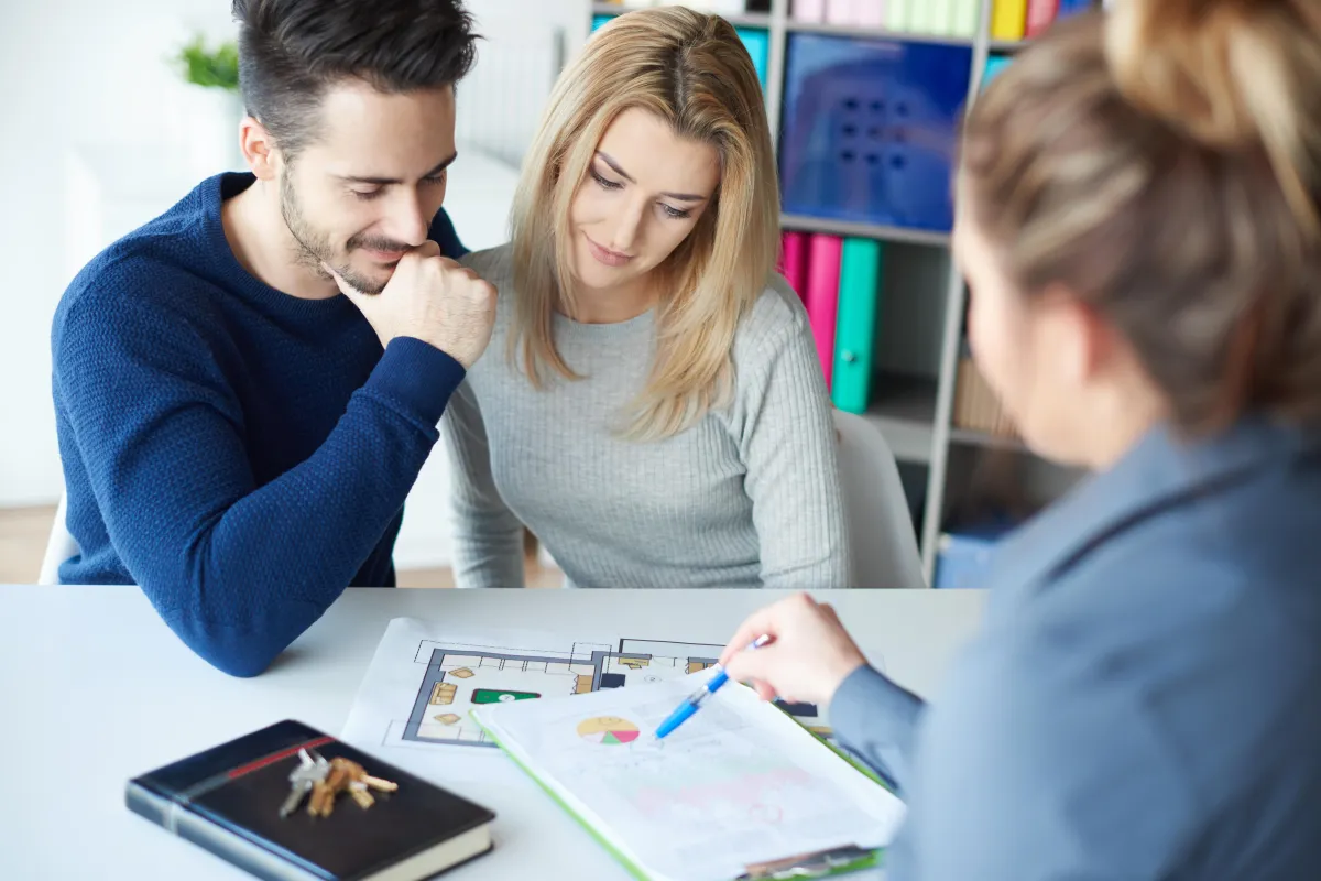 Real Estate agent going over paperwork with a happy couple