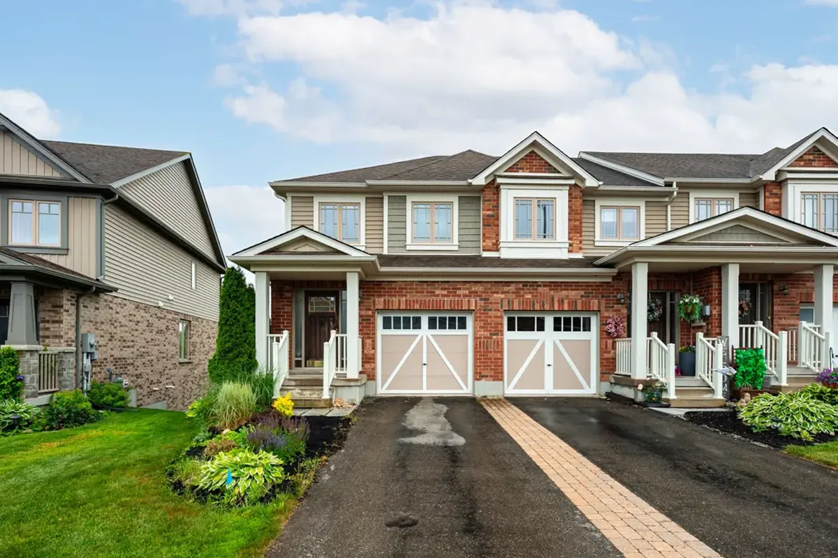 Red brick and brown siding 2-storey townhome with built-in 1-car garage located in the Veteran's Park neighbourhood in Orangevilleu