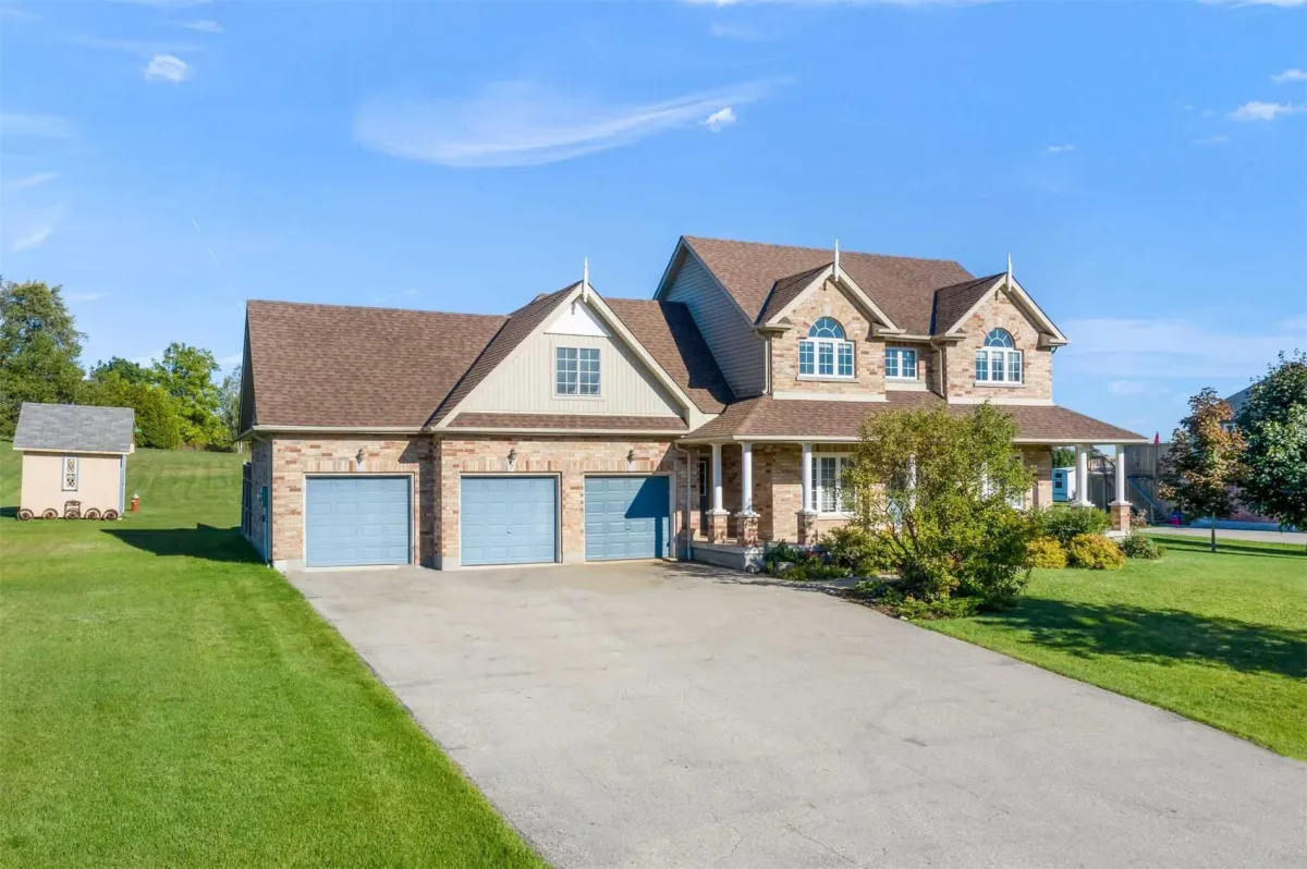 Light brick 2-storey detached home with attached 3-car garage on a large lot located within the Hamlet of Camilla in Mono, Ontario
