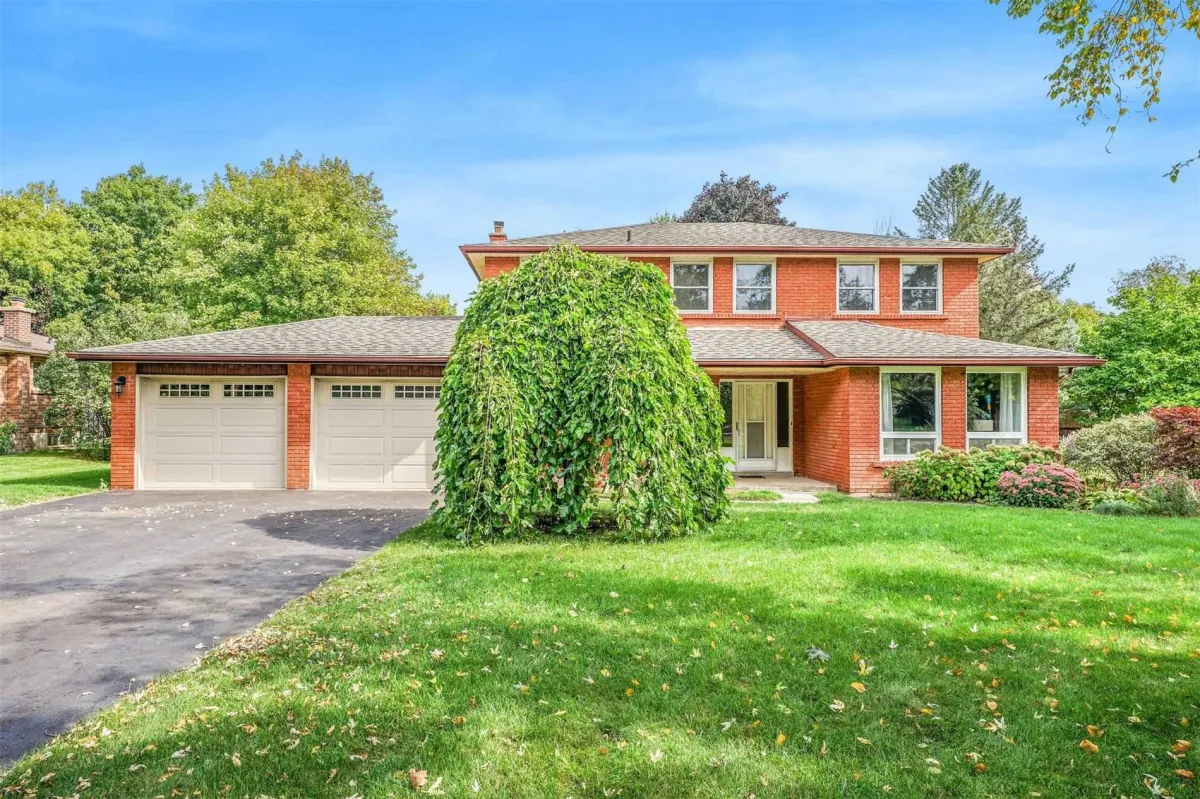 Large red brick 2-storey home with attached 2-car garage located in Caledon East