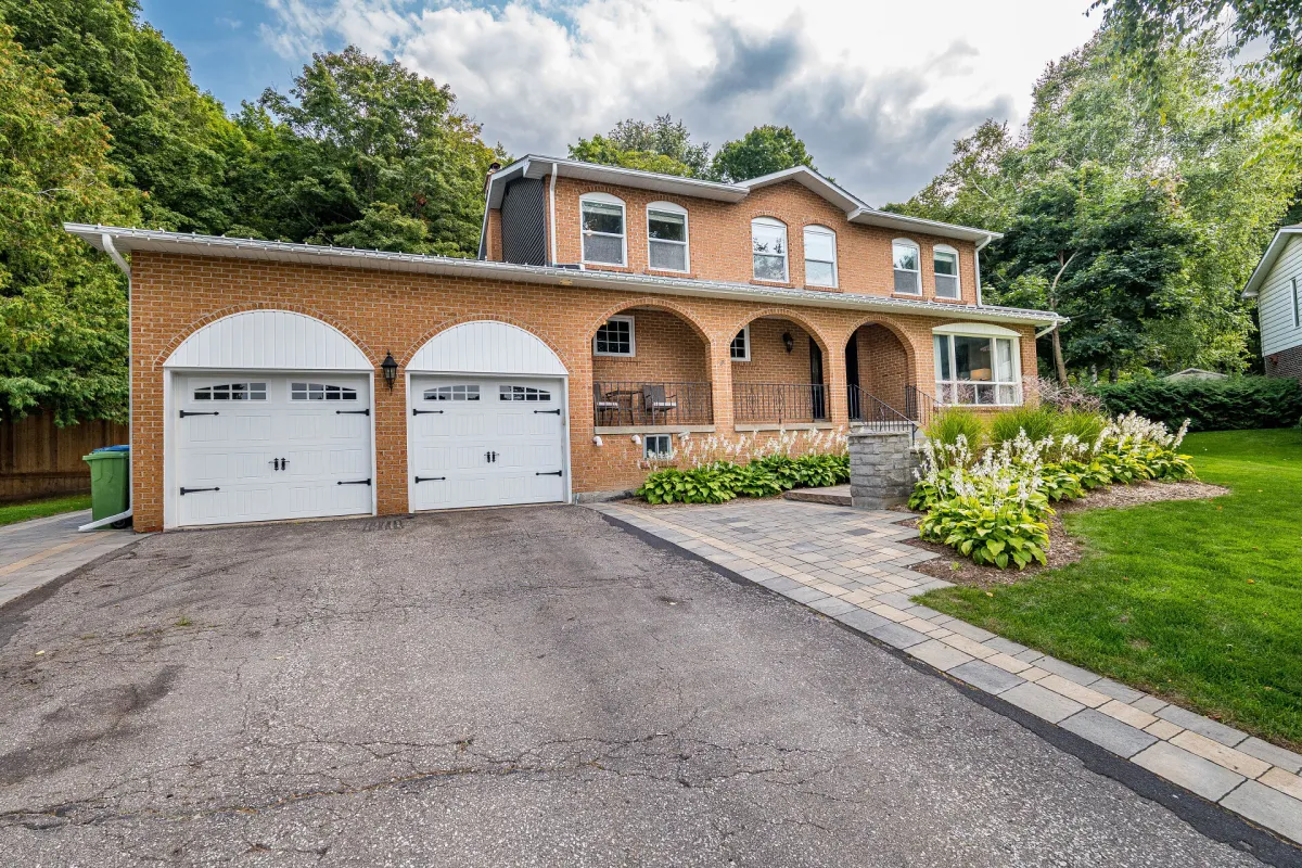 Large red brick 2-storey home with attached 2-car garage located in the Caledon East Public School Area