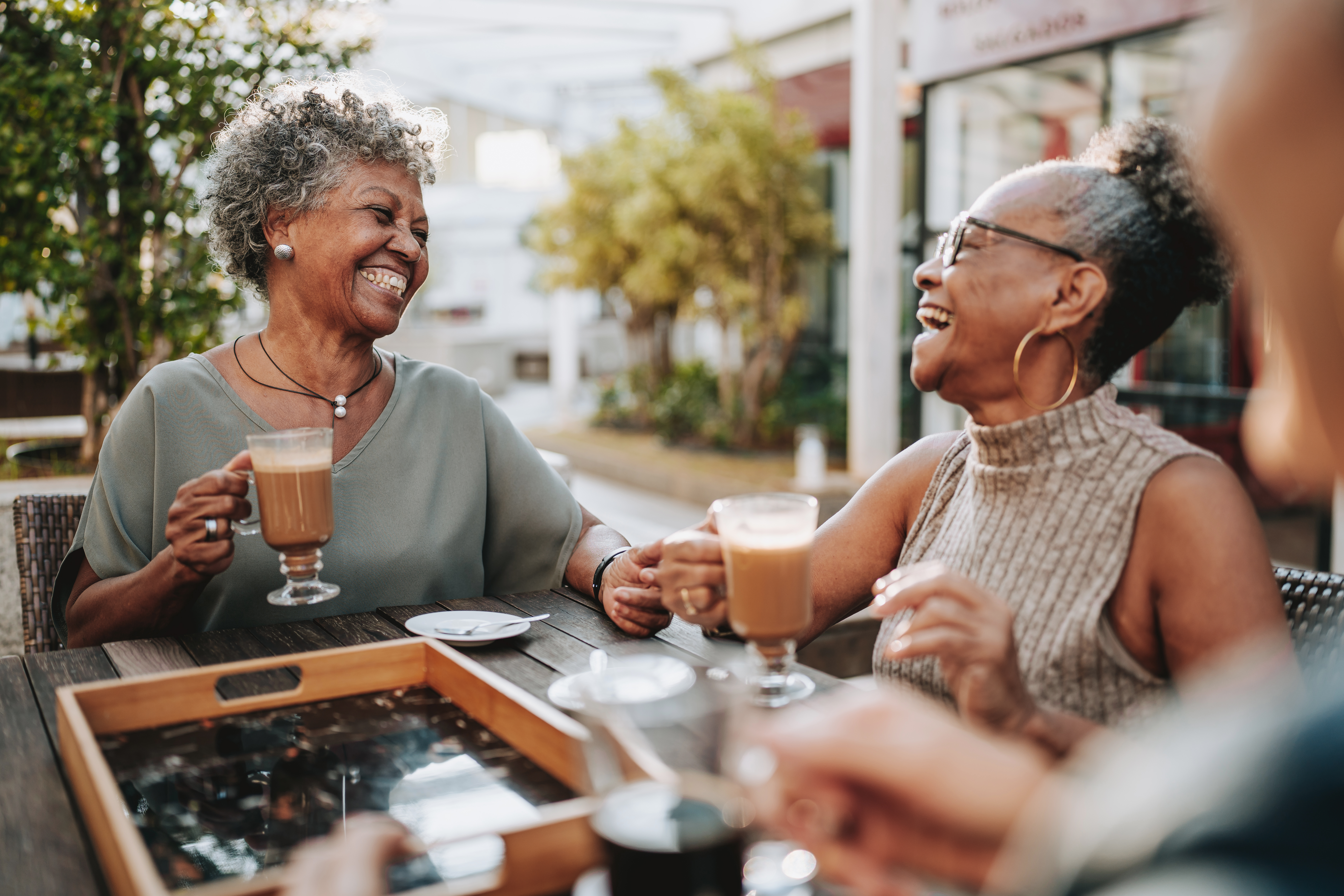 senior friends at coffee shop smiling and laughing