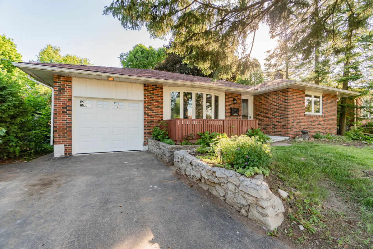red brick bungalow home with attached 1-car garage located in Acton, Ontario