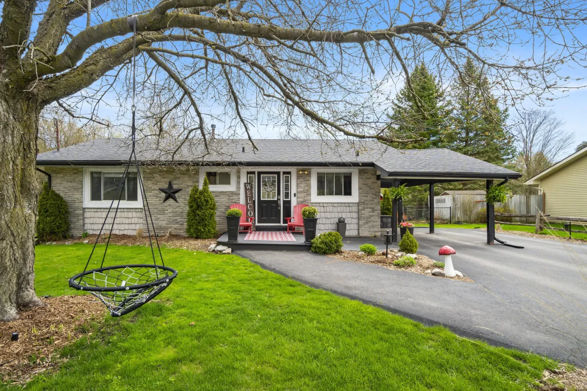 Detached grey bungalow with large driveway and spacious lawn located in Hillsburgh, Ontario