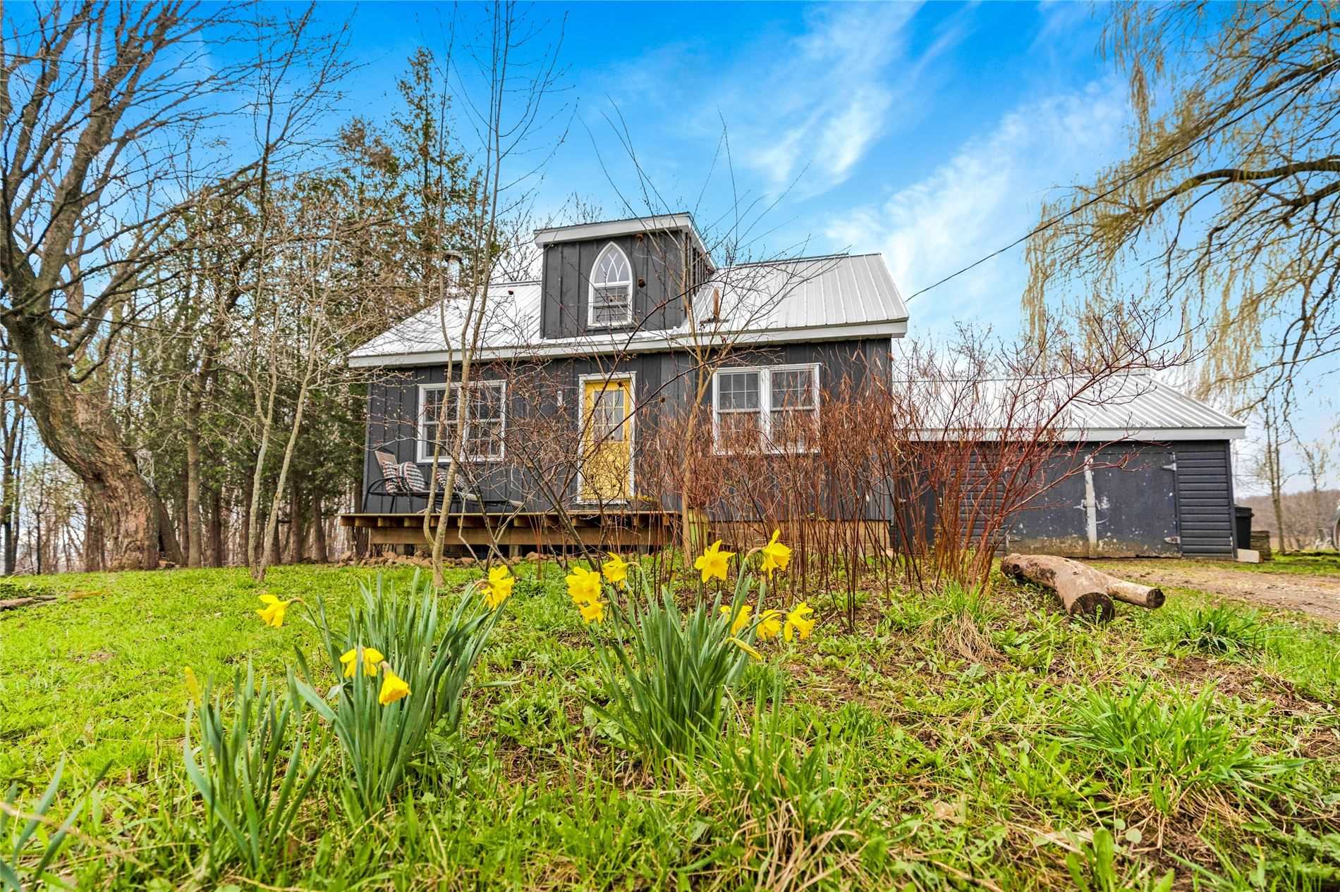 2-storey country home with yellow front door located in the Lavender area of Mulmur Township