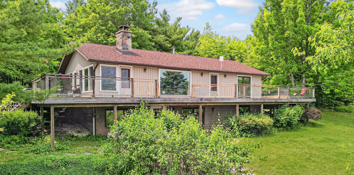 Raised bungalow with wrap around veranda and walk-out basement surrounded by mature trees located in the Honeywood area of Mulmur Township