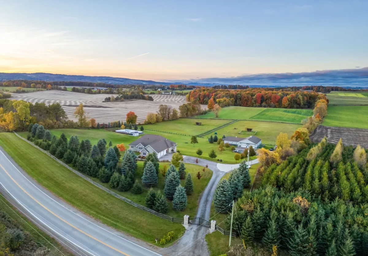 Image showing a spacious country property with large estate home and barn surrounded by farm fields and trees located within the Black Bank area of Mulmur Township
