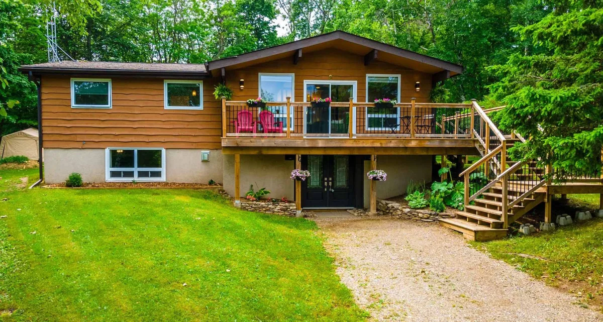 Raised bungalow with wrap around veranda and walk-out basement surrounded by mature trees located in the Black Bank area of Mulmur Township