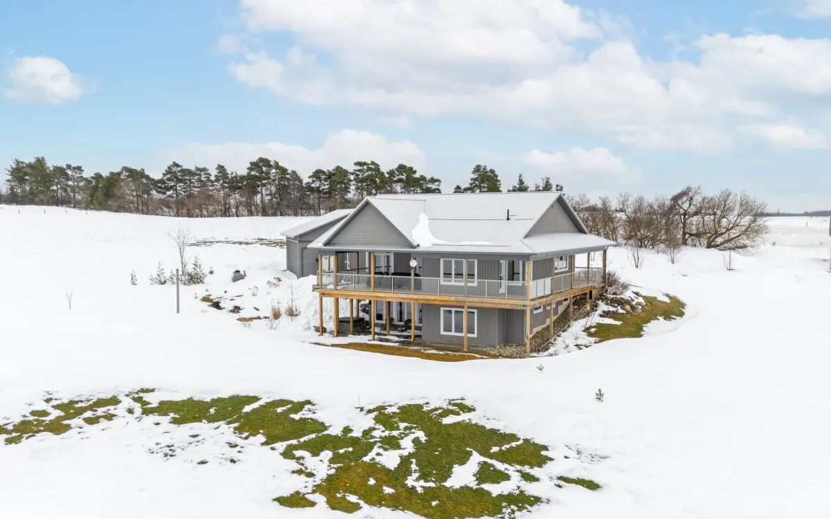 Raised bungalow with wrap-around veranda and walk-out basement located in the Black Bank area of Mulmur Township