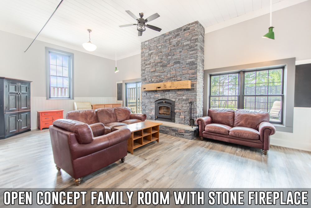 Open concept family room with stone fireplace in converted schoolhouse located at 586274 County Road 17, Mulmur