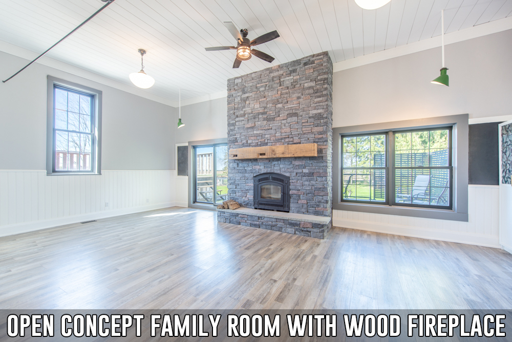 Open concept family room with stone fireplace in converted schoolhouse located at 586274 County Road 17, Mulmur