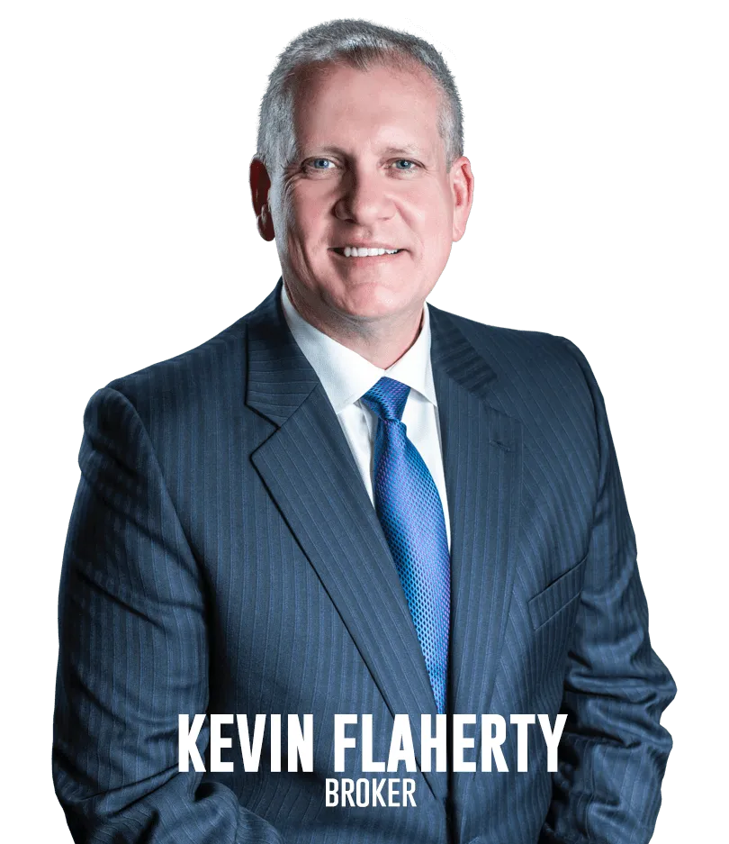 Kevin Flaherty, real estate broker, smiling in a professional suit with a blue tie, representing the Flaherty Team