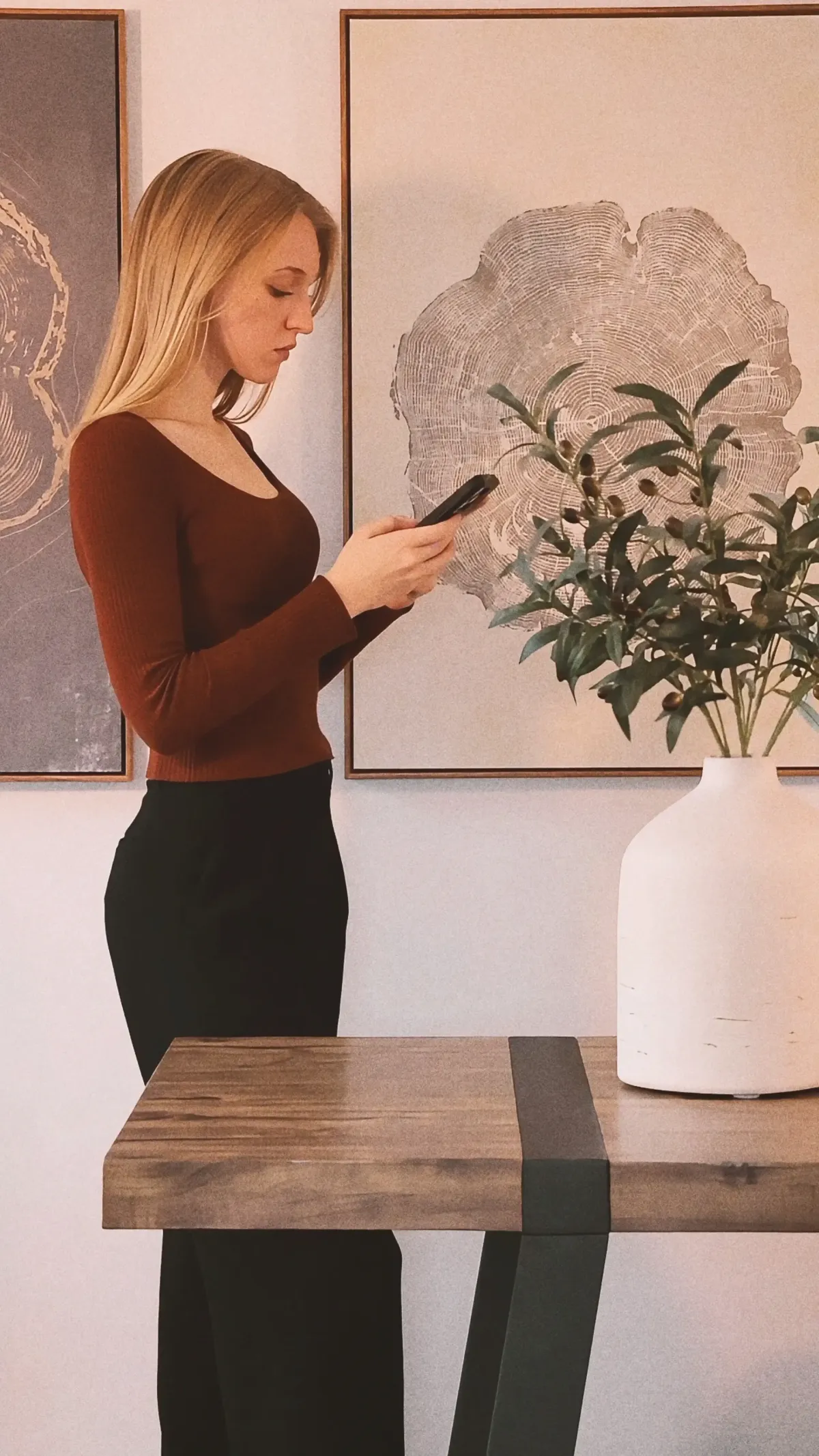 Founder answering emails on phone in dining room scene