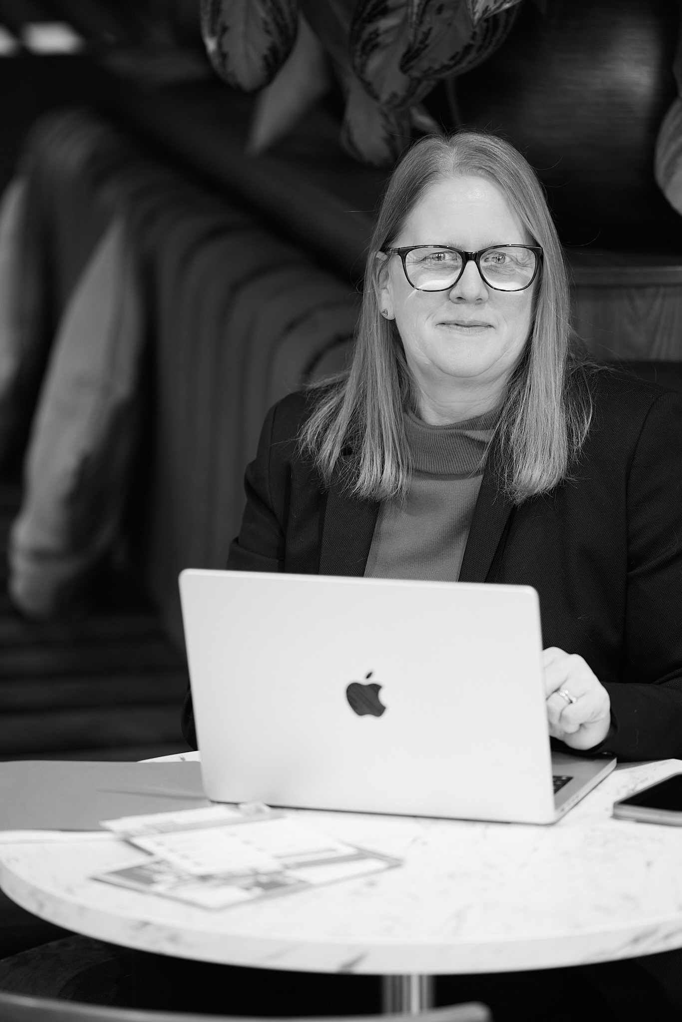 a fair skinned woman with blonde hair. she is wearing glasses and smiling.