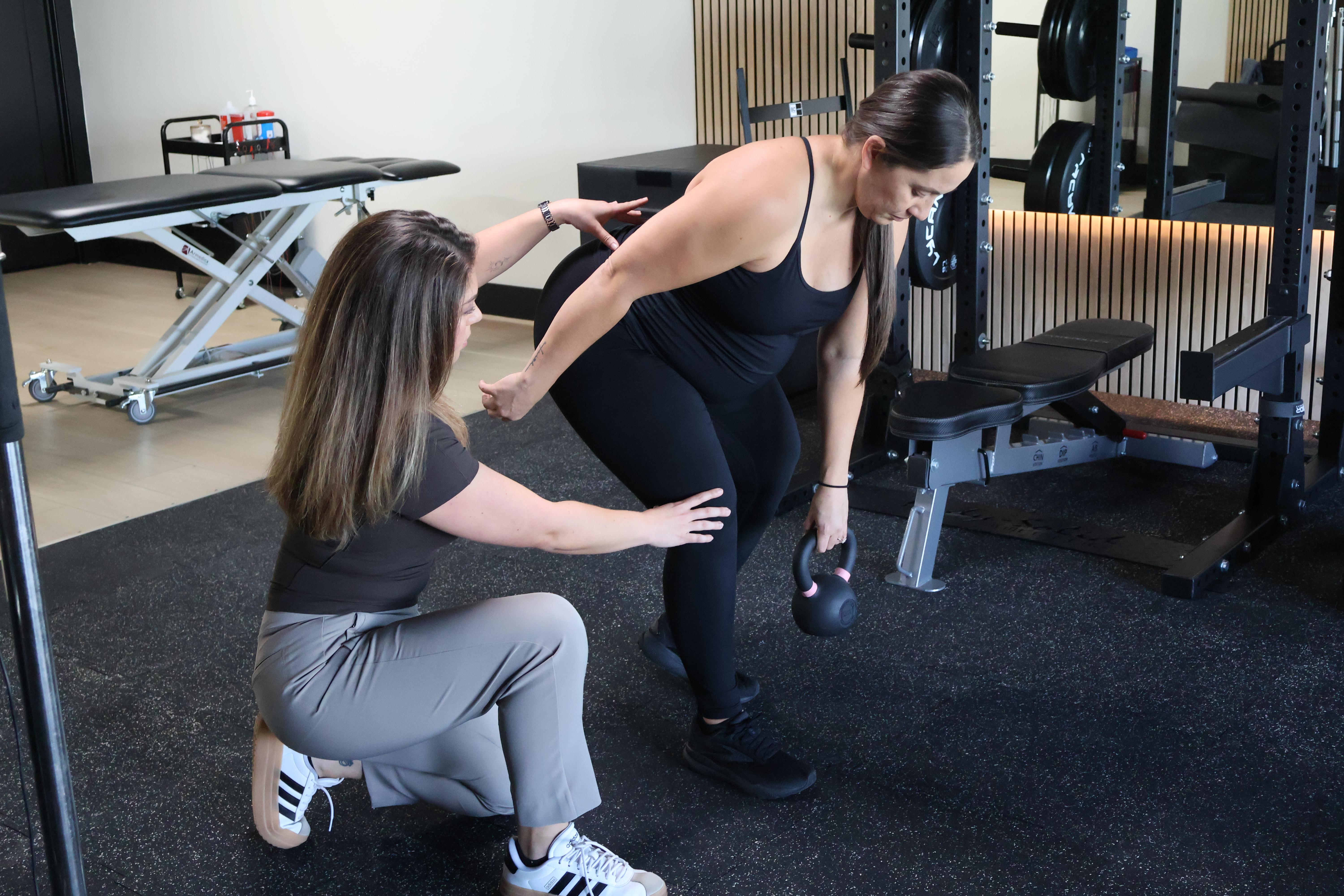 Physical therapist guiding a patient through therapeutic movement at Revive Physiotherapy