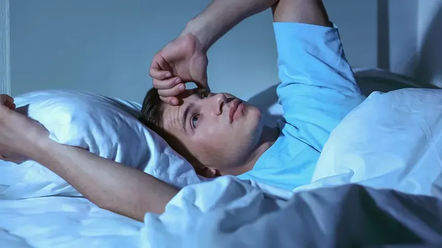 person awake at night because of pain