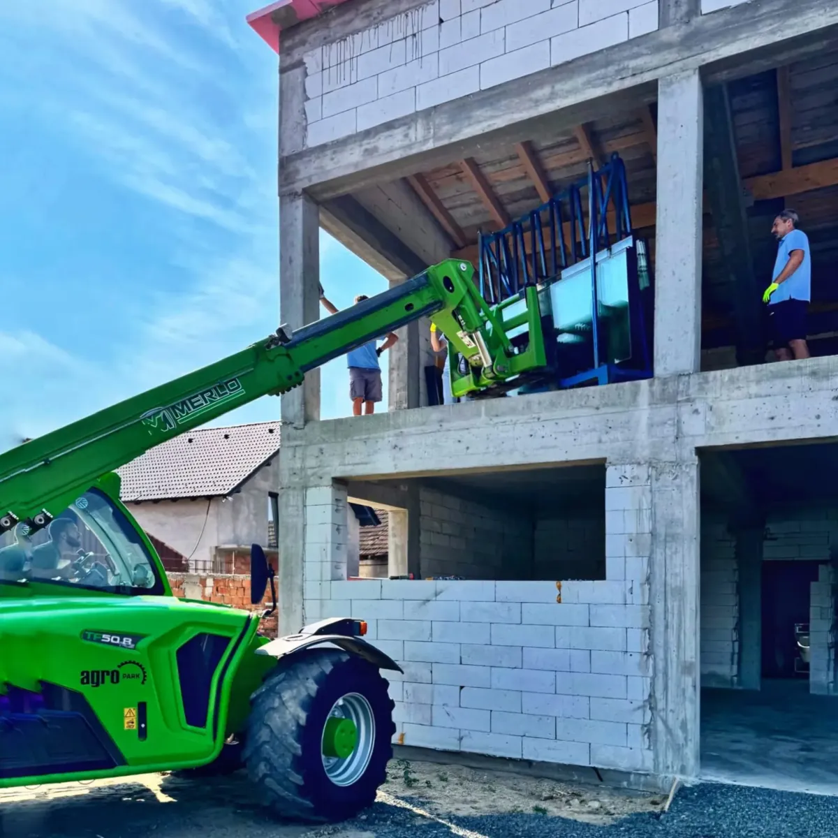 Proces de instalare a geamurilor într-o construcție nouă cu ajutorul unui utilaj.