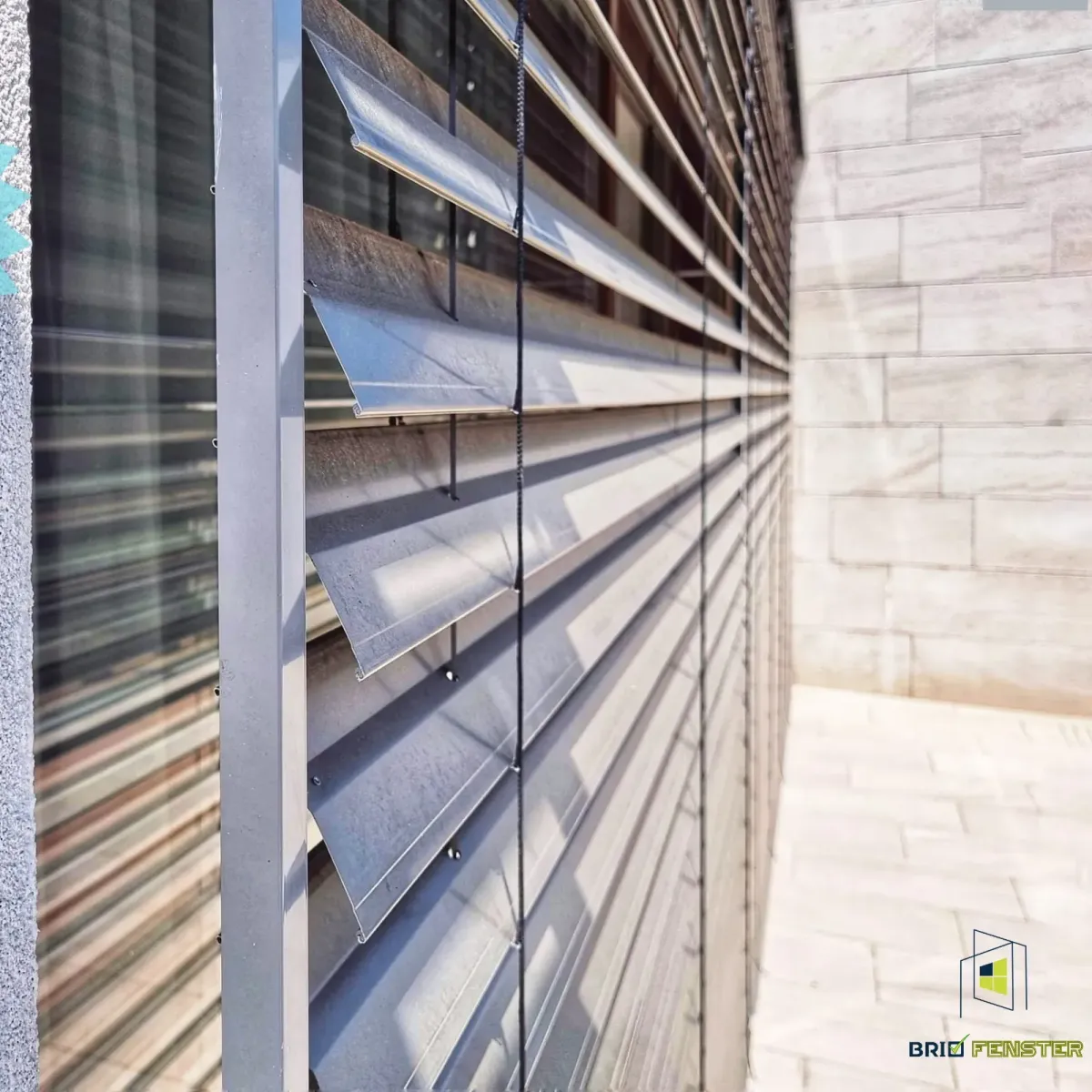 Jaluzele metalice exterioare montate pe fațada unei clădiri moderne, pentru protecție solară și controlul luminii naturale.