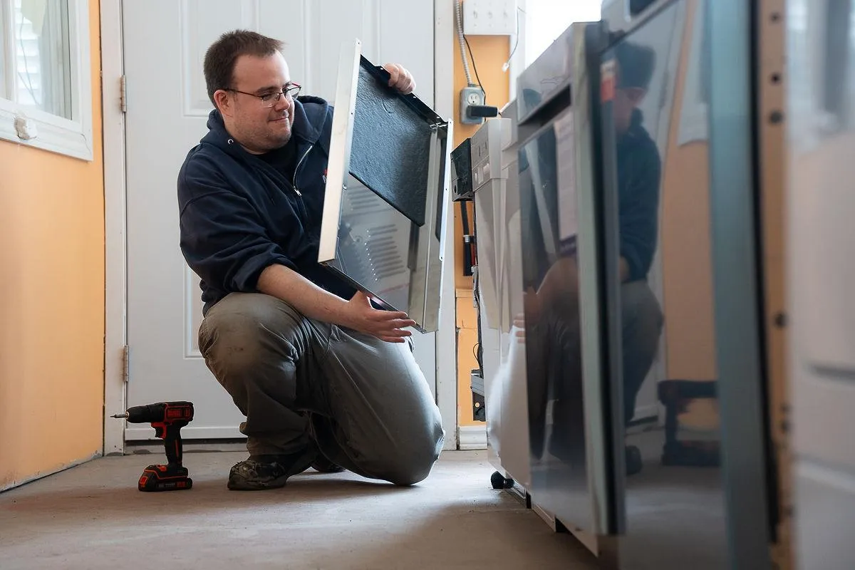 Al's Appliance technician servicing a refrigerator door in Kitchener