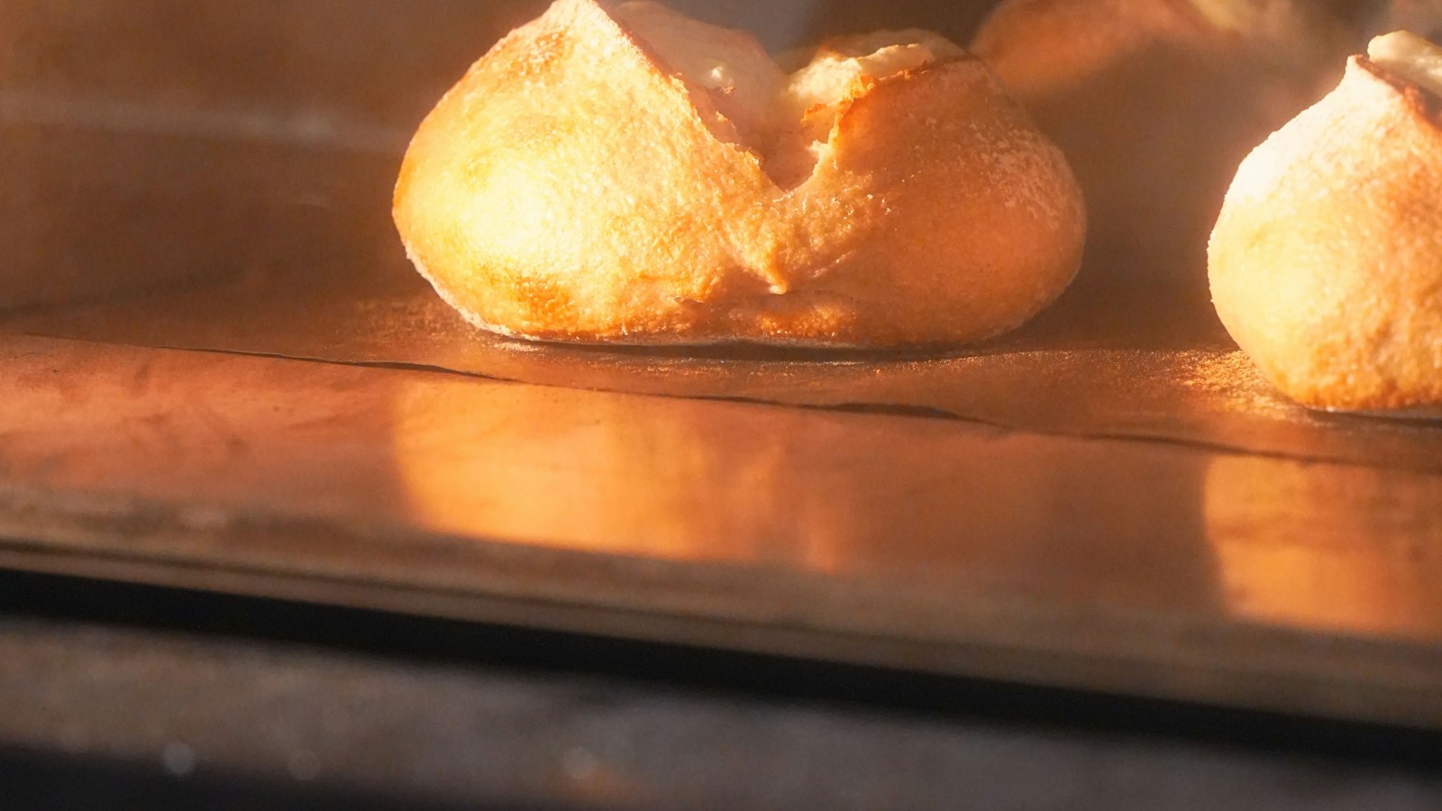 Bread baking inside an oven with the light on