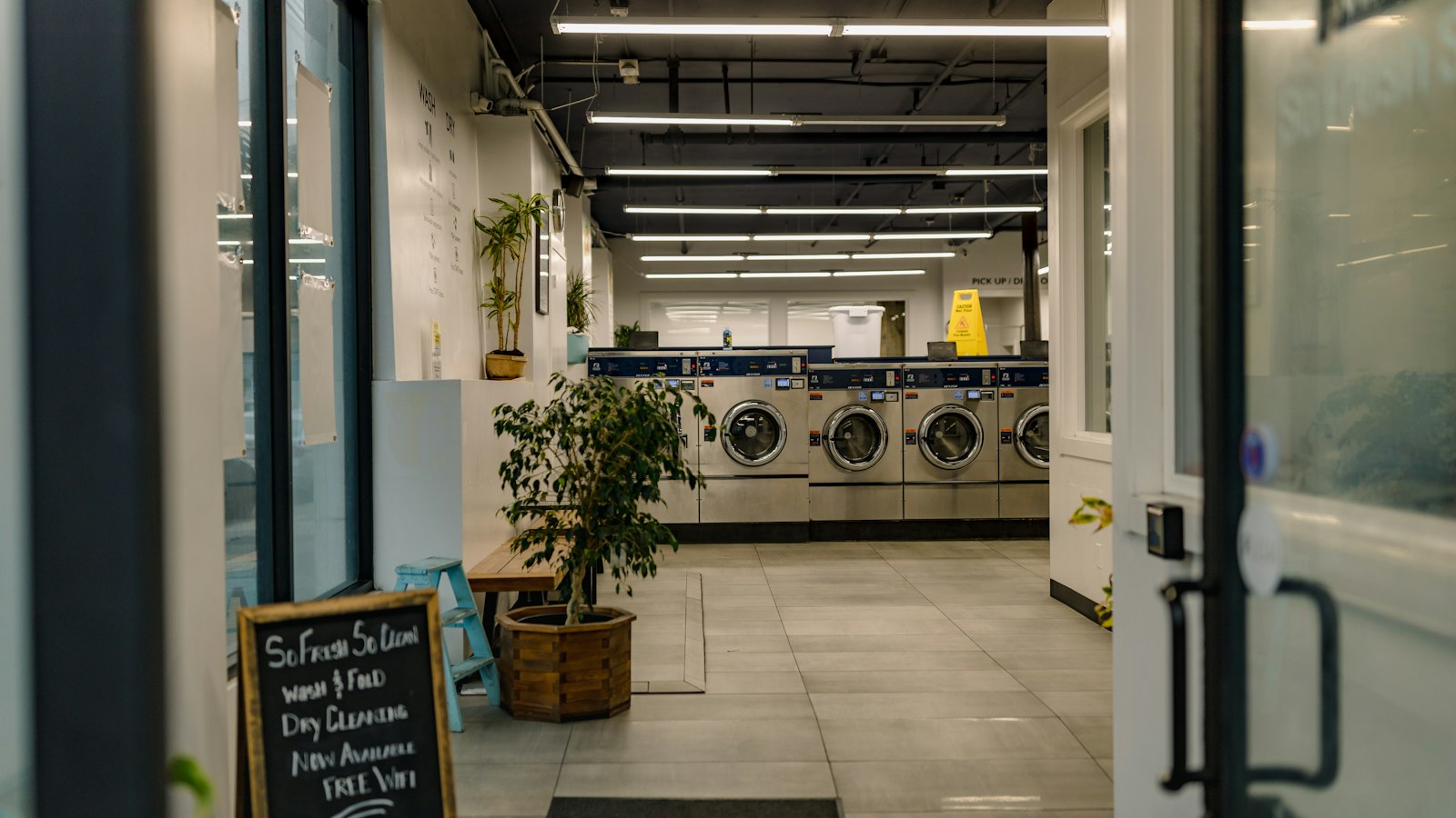 Row of front-load machines in a laundry room