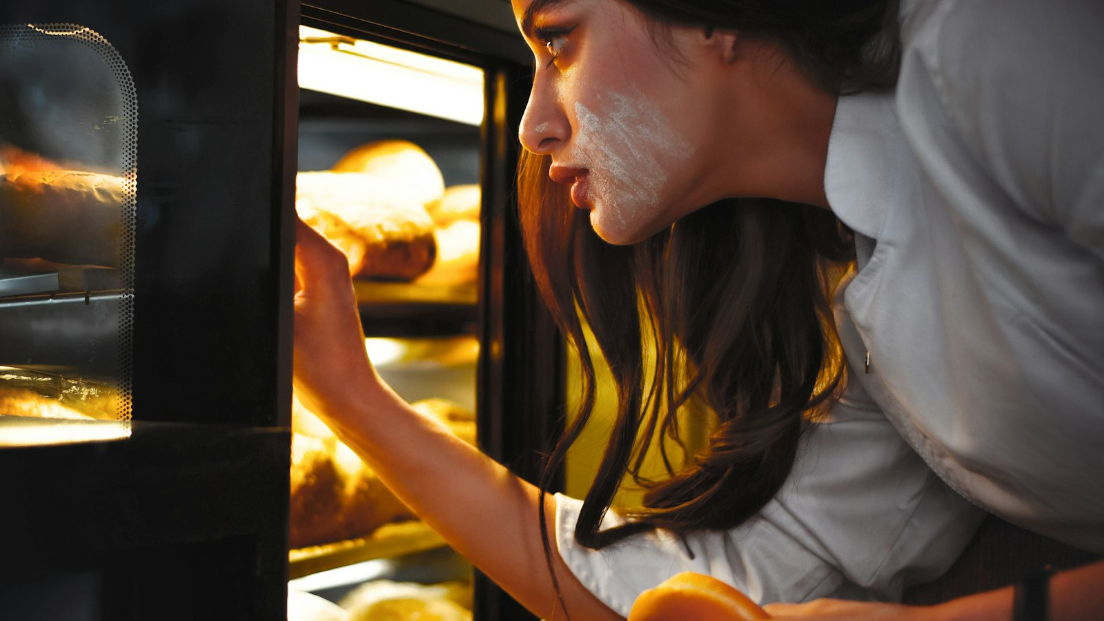 Woman checking food in a wall oven