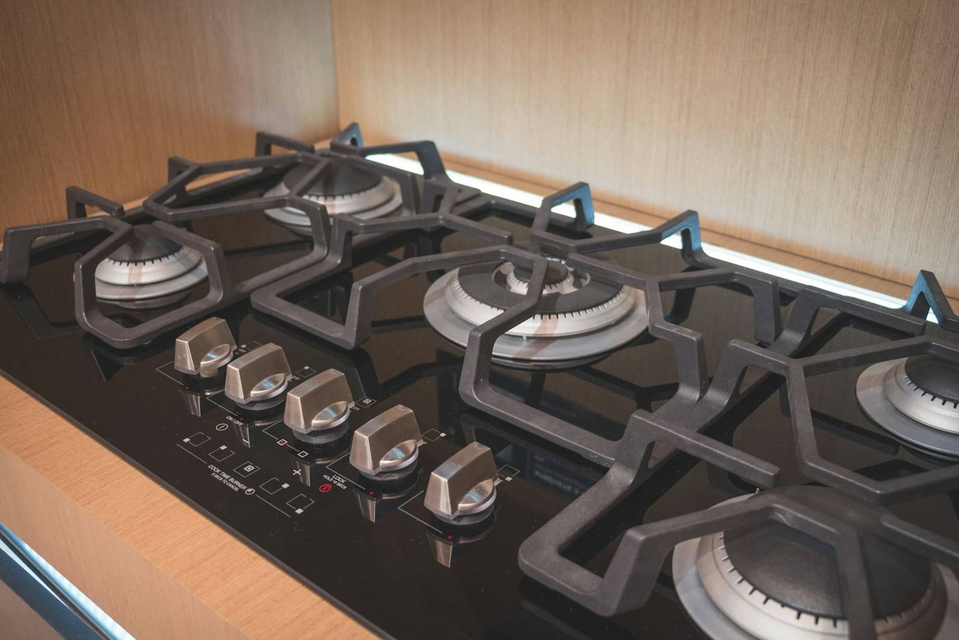 Gas cooktop burners and control knobs on a black glass stovetop
