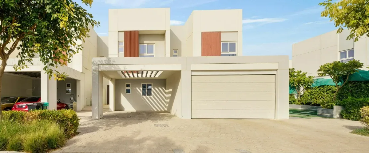 Modern house exterior with driveway and garage in a clean residential neighborhood.