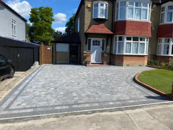 Residential house with newly paved driveway made of stone blocks in front yard.