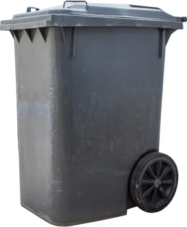 A dark grey plastic wheeled trash can, slightly worn, with its lid closed, isolated on a white background.