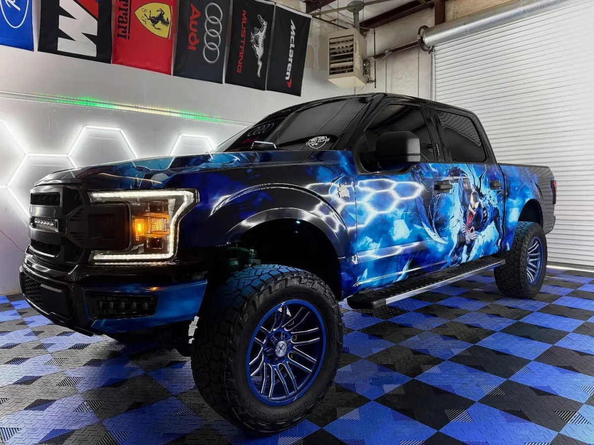 Venom Tint's blue-wrapped shop truck inside the Acworth shop