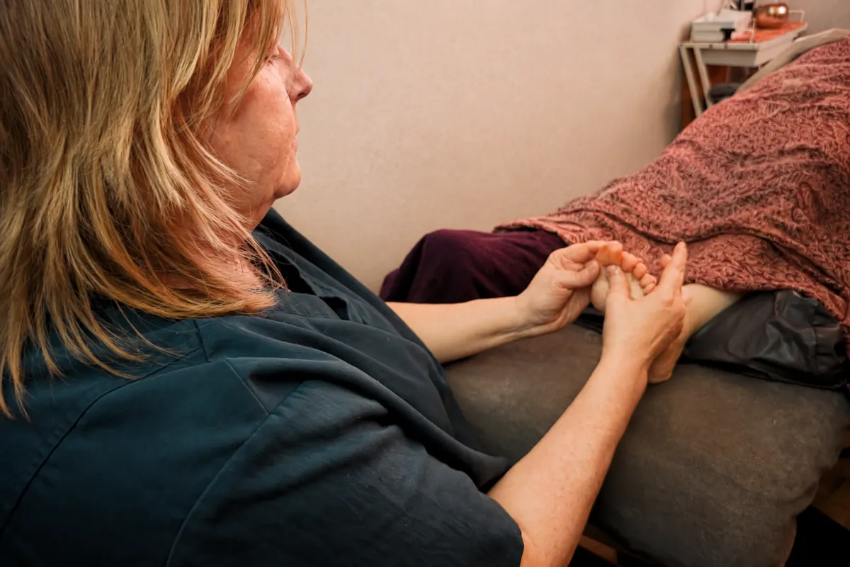 Lindsey Brookes demonstrating Reflexology pressure techniques in her working clinic in Nuneaton