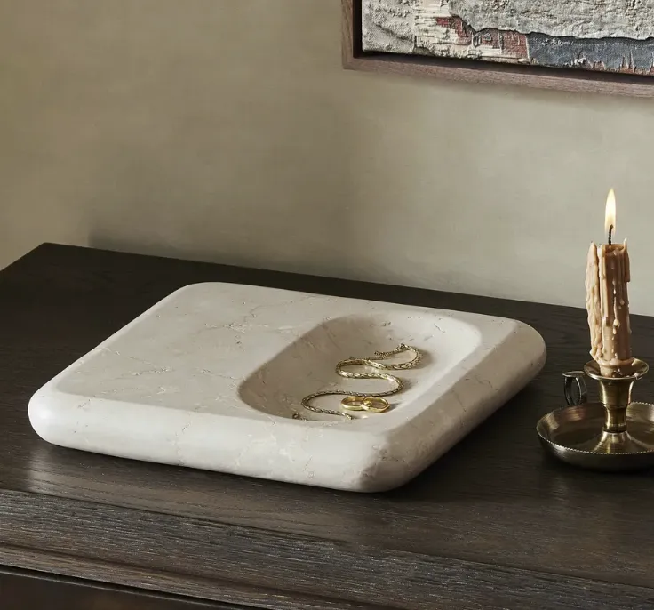 Polished marble catch all tray on a dark stained wooden credenza, an organic wax candle half melted in a vintage brass candle holder sits off to the side. Curated by Brooke Sligar with The Collective Haus, based in Boise, ID. 