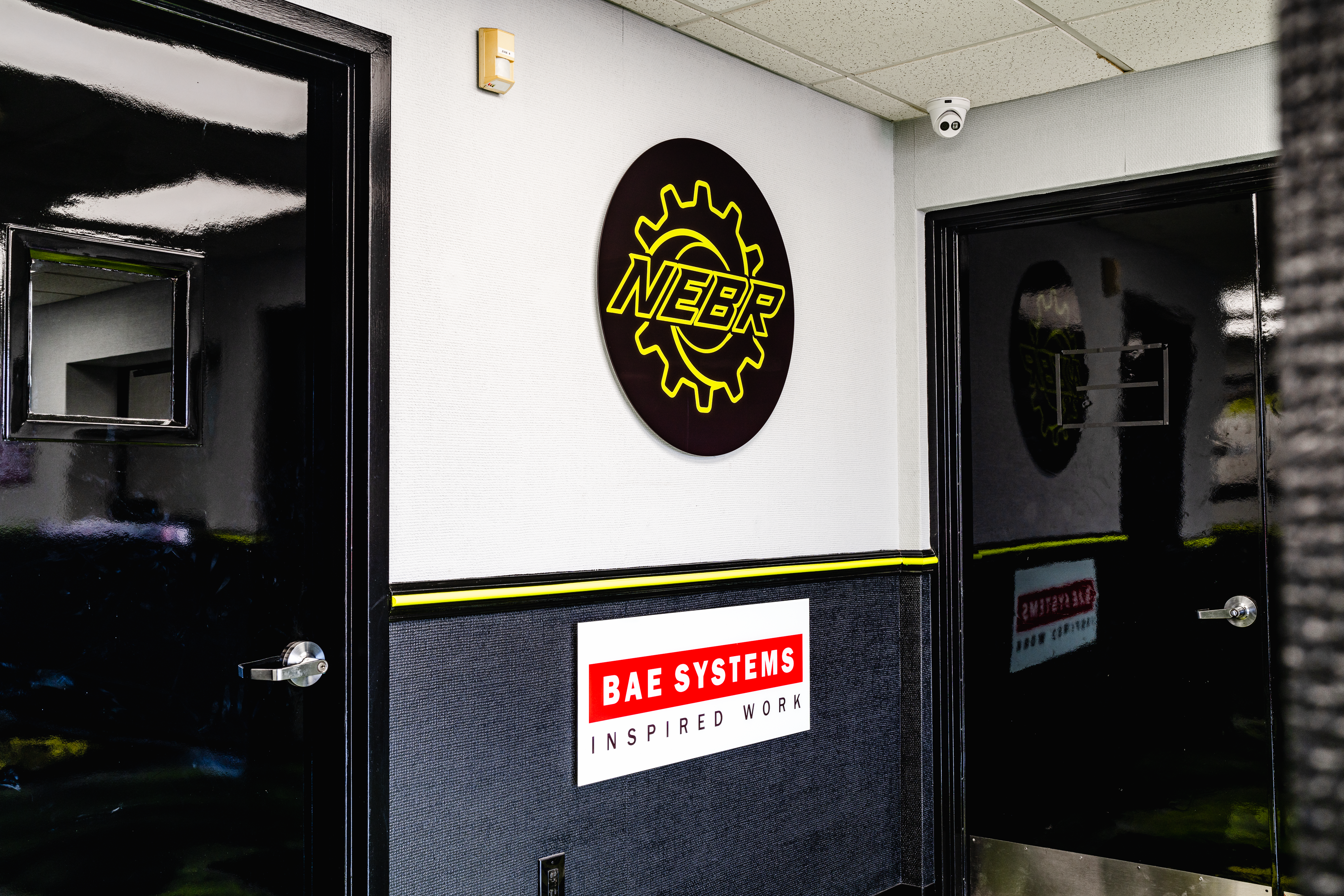 Entrance hallway of NEBR facility with NEBR logo and BAE Systems dealer sign