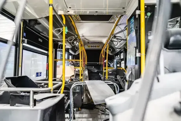 Technicians servicing HVAC and air conditioning systems inside a transit bus