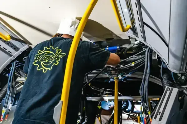 NEBR technician performing structural and electrical work inside transit bus