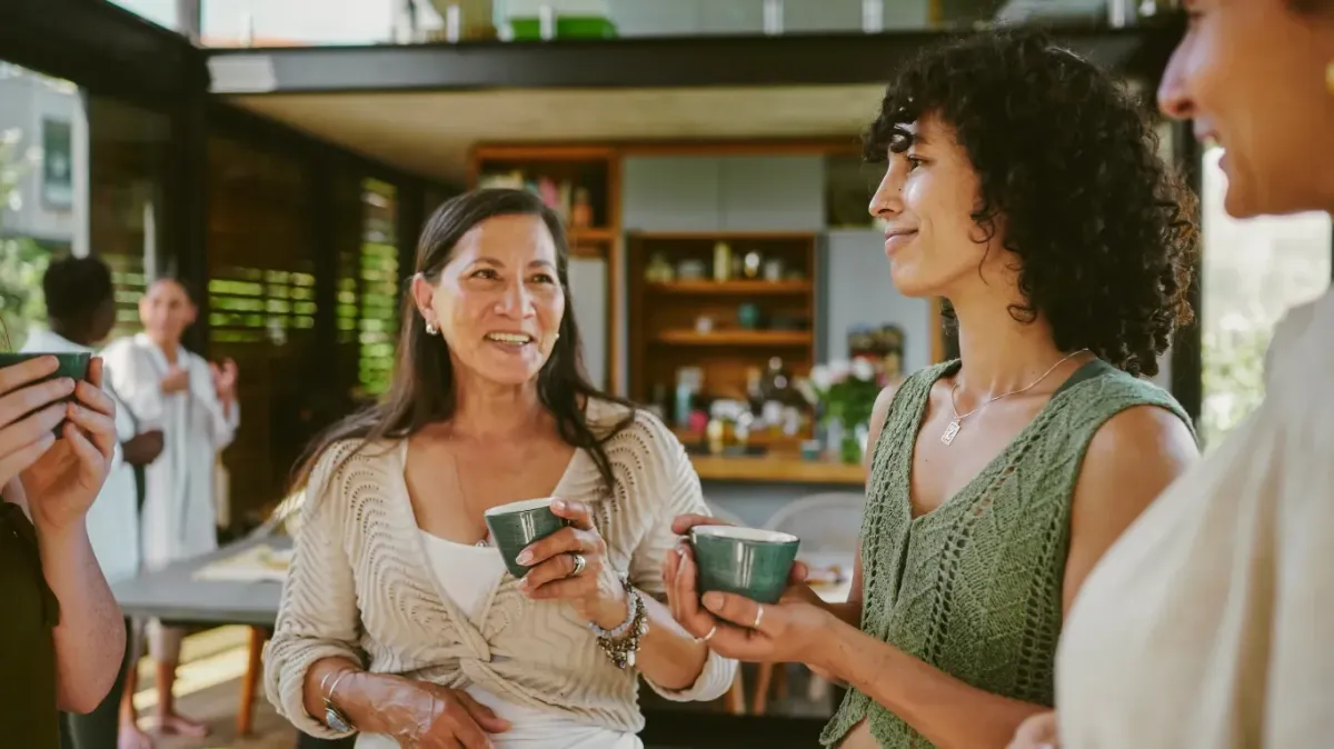 Workplace Wellness Leadership: 7 Mantras for Healthy Teams — A warm, modern kitchen gathering where colleagues socialize over drinks, fostering connection, balance, and community as part of healthy team culture.