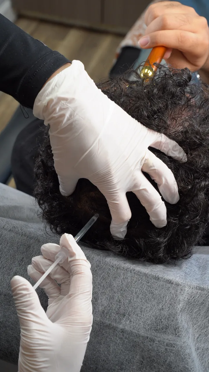 Aesthetic medical practitioner delivering precise, subtle facial injectables in a luxury clinical setting