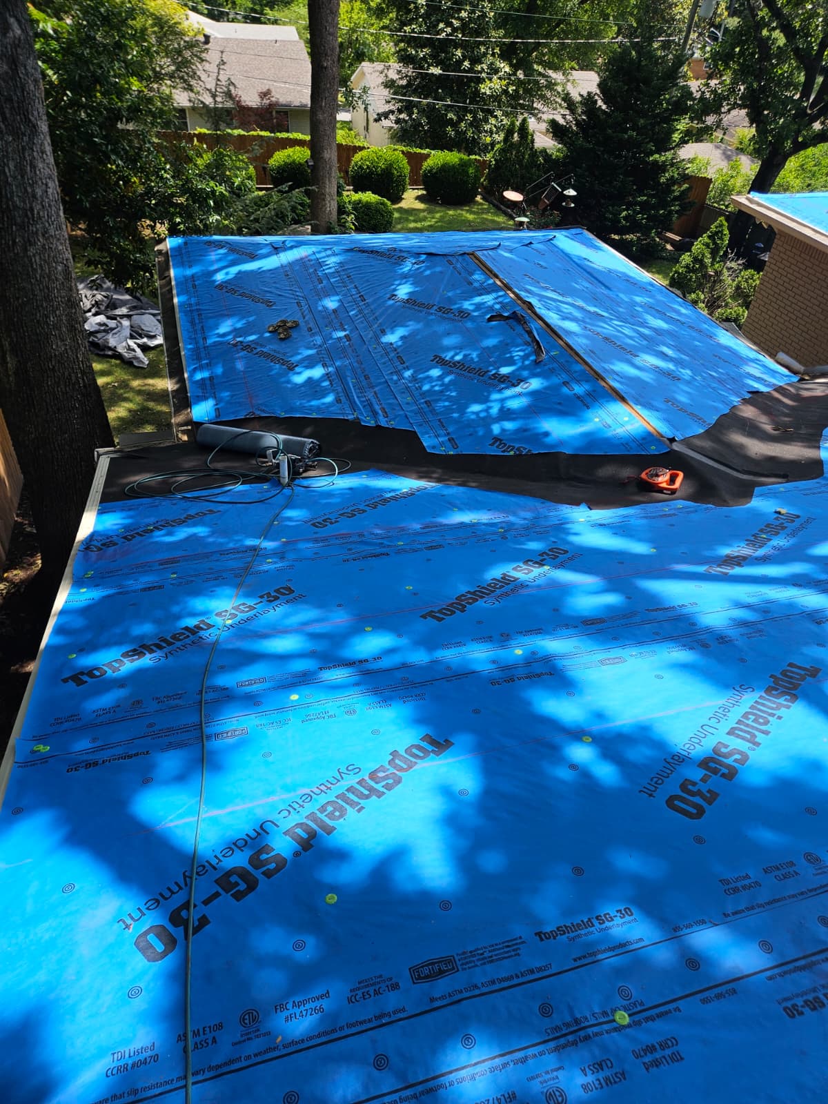 Blue tarp applied onto a roof that is currently undergoing a fresh install.