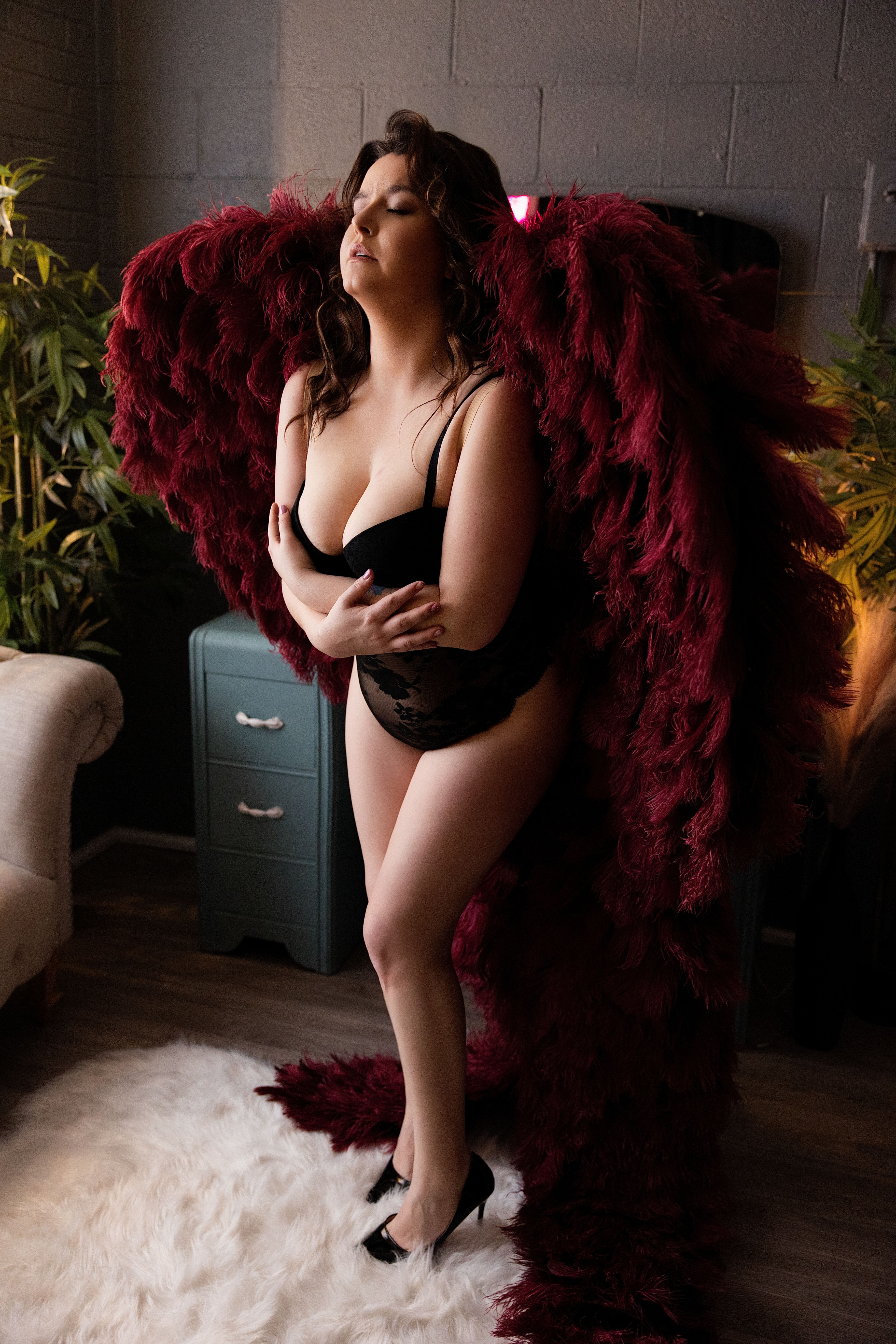 Woman wearing dramatic angel wings in soft light, luxury boudoir Spokane