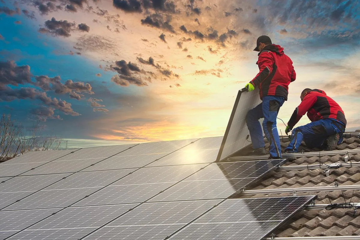 Technician installing a solar panel on a roof in Lake Havasu.