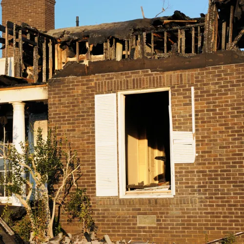 Public adjuster inspecting fire and water damage inside a residential property