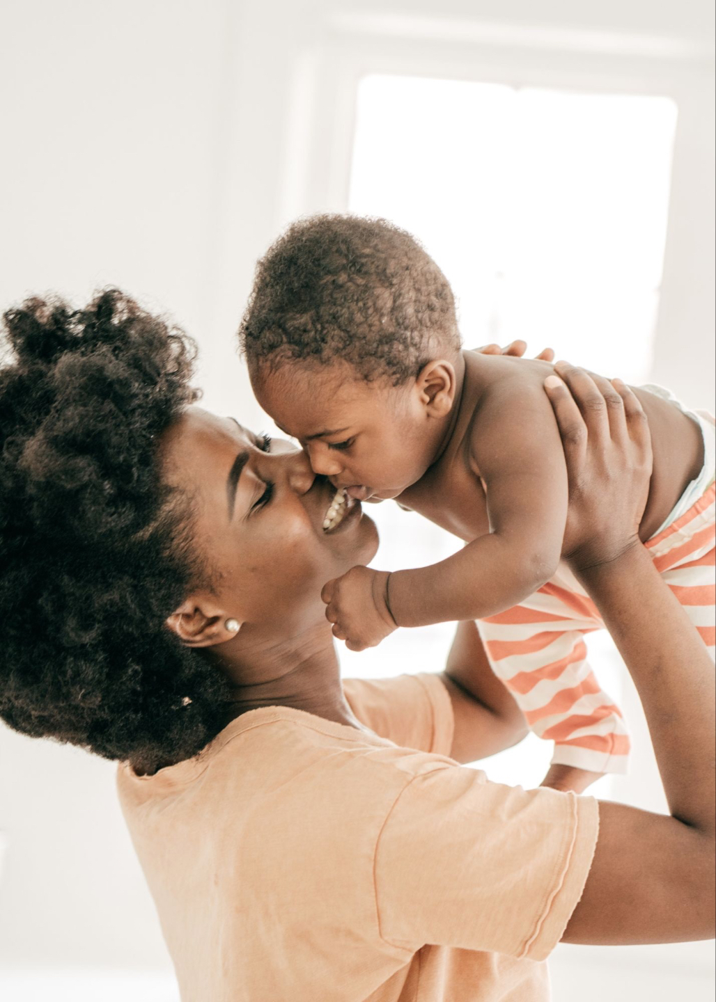 new mother gently holding her newborn baby, receiving compassionate postpartum care from Elephant Baby.