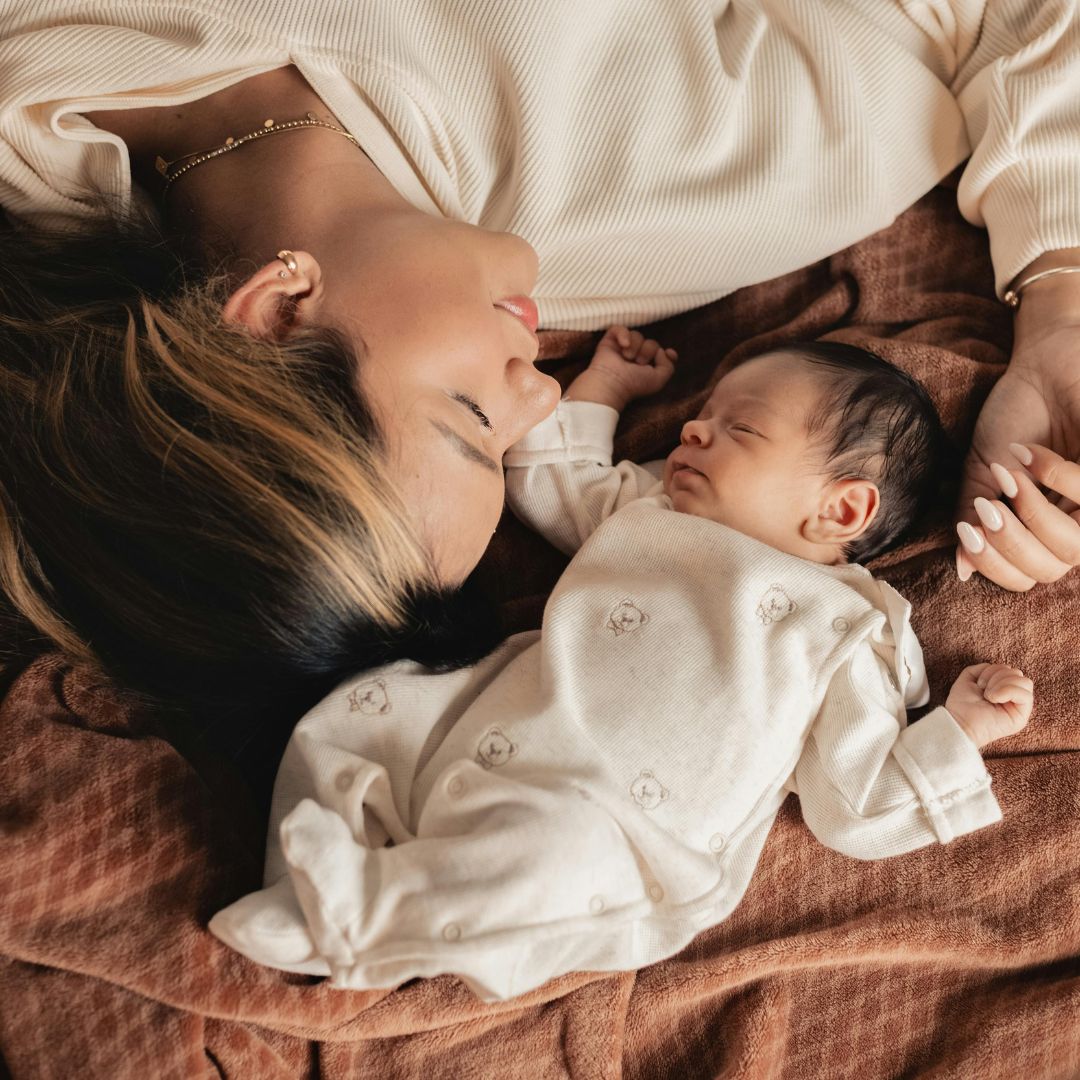 mother resting with newborn and utilizing overnight and daytime doula support from Elephant Baby, the leading postpartum care agency in St. Louis, MO and Metro East, IL