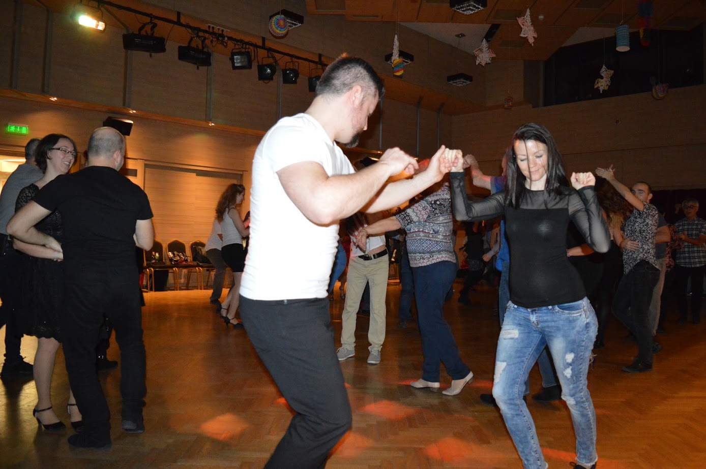 Ballerinas practice at a barre in a theater.