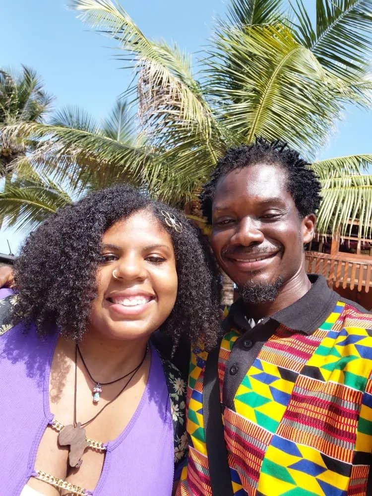 Client Jeannie Merant and GTFOA agent smiling together in front of her new apartment after a successful home search in Ghana.