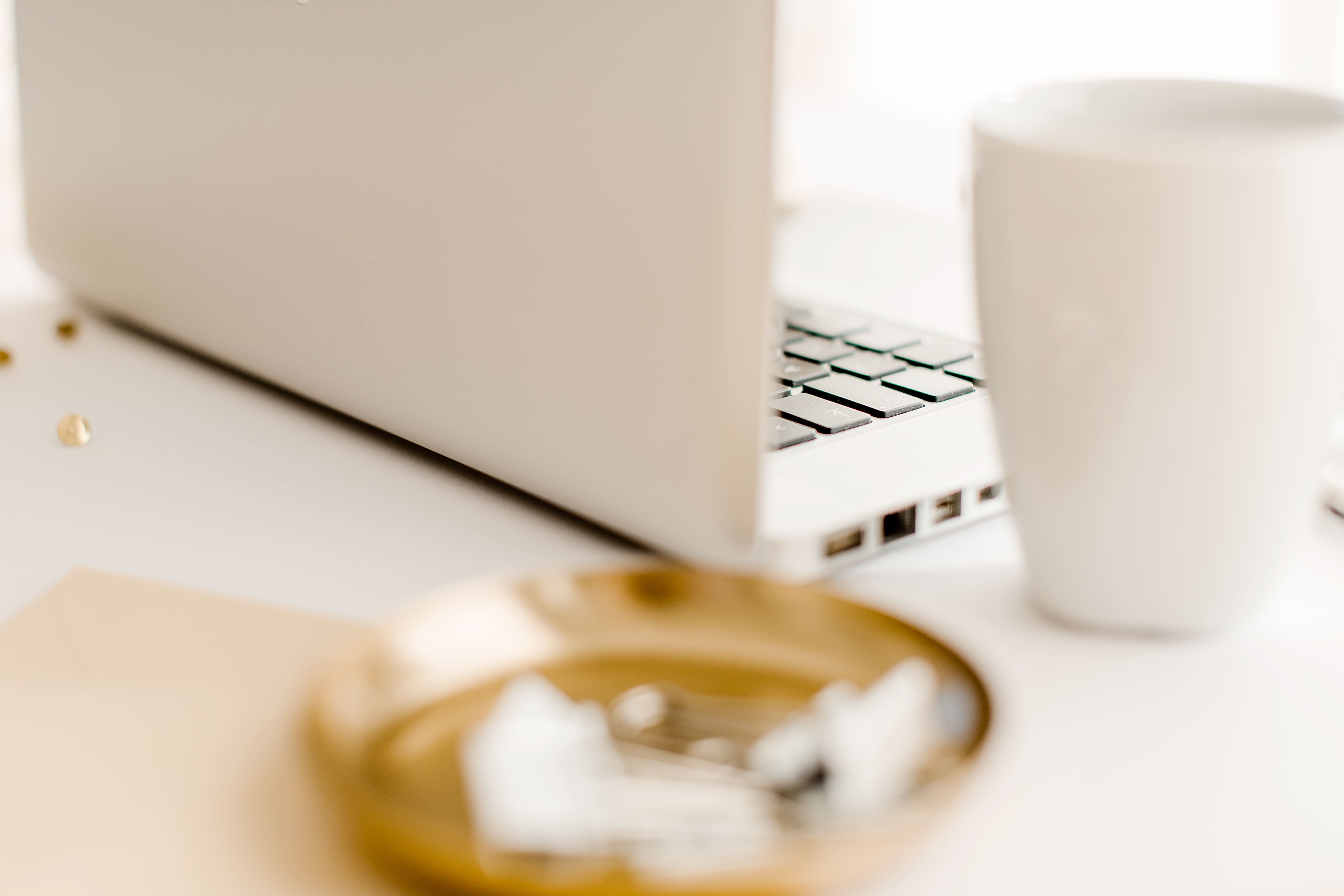 Frauenhände am Laptop, Kerze und grüner Zweig im Vordergrund